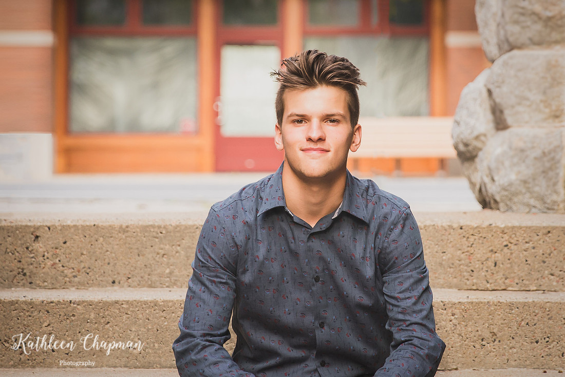 Handsome senior guy on steps in brick alley in Massena NY St. Lawrence county family photographer