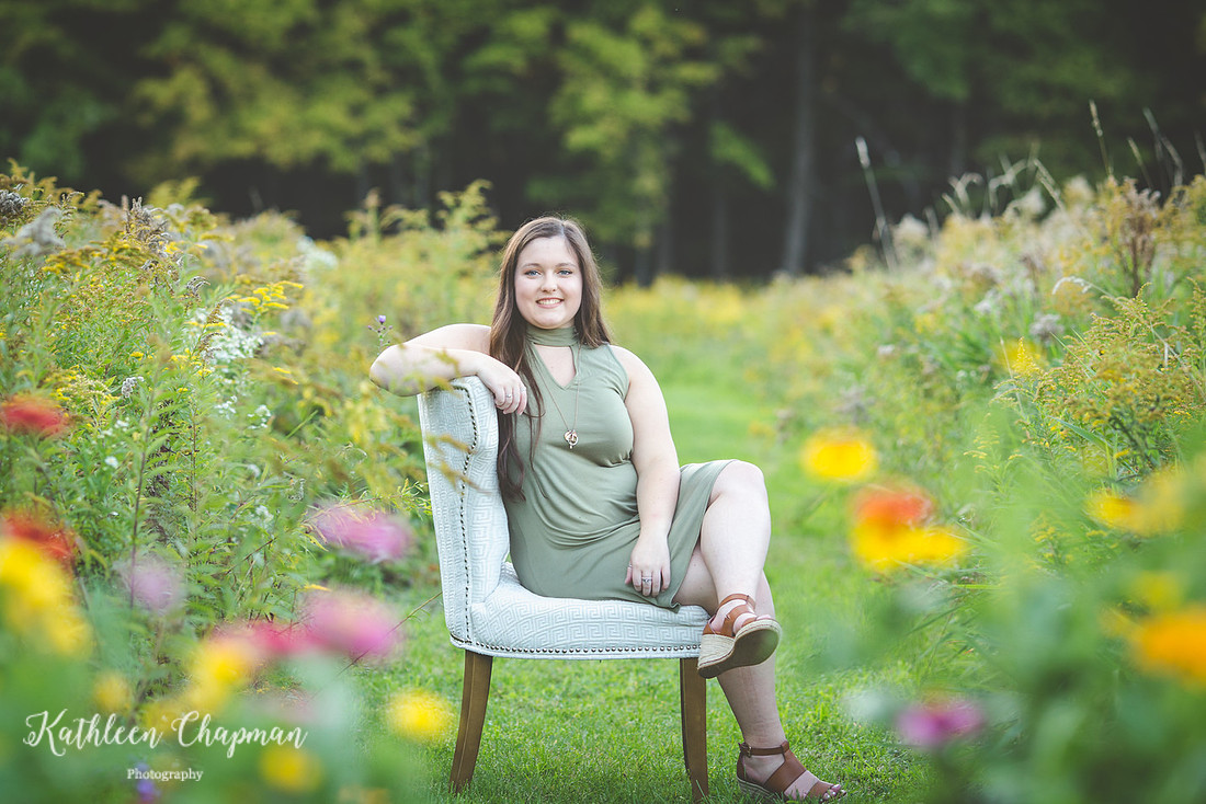 senior girl sitting in chair in wild flower garden potsdam ny family photographer