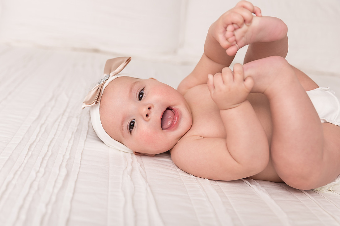 smiling baby girl playing with toes massena ny child photographer