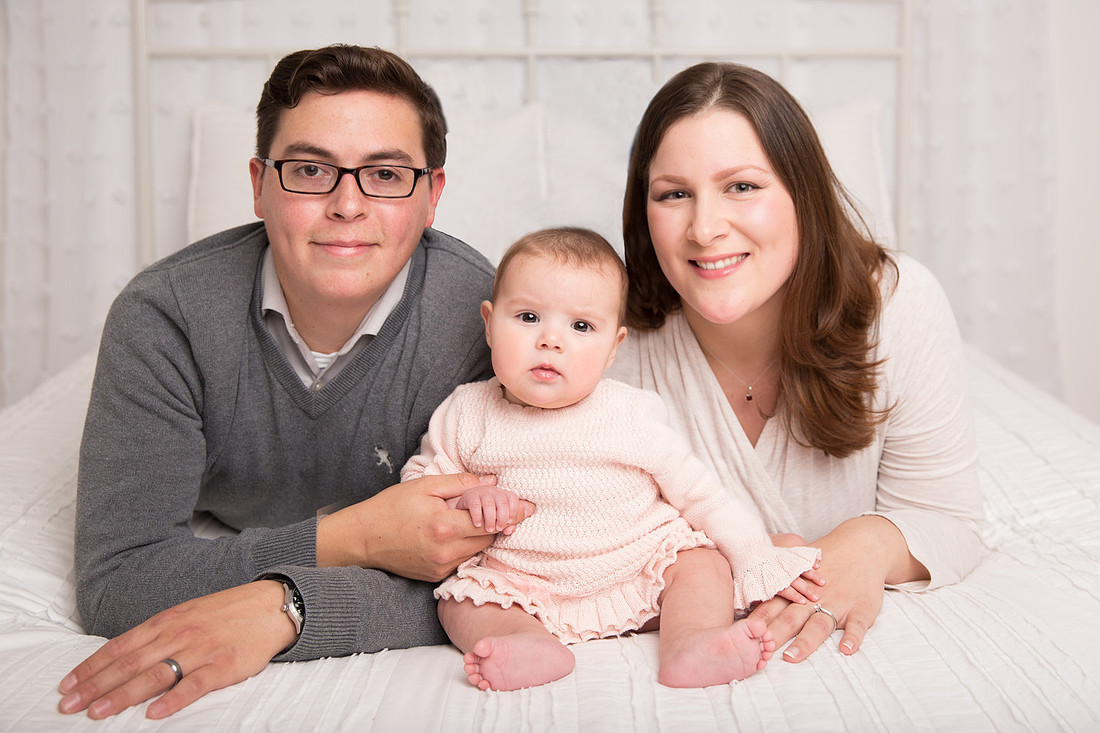 baby girl and parents on white bed dickinson center ny family photographer